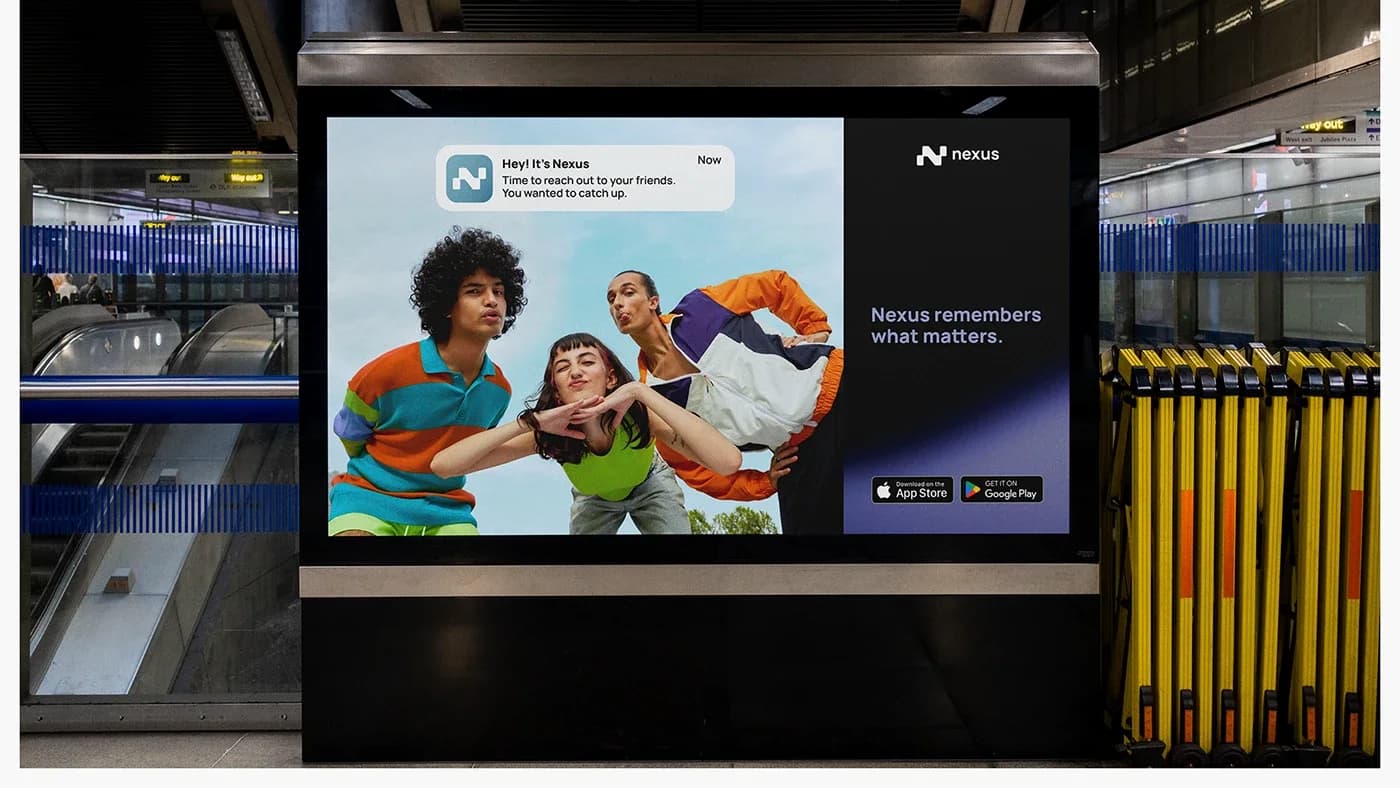 A Nexus digital panel in a transit station showing three friends mid-laugh beside the line “Nexus remembers what matters”