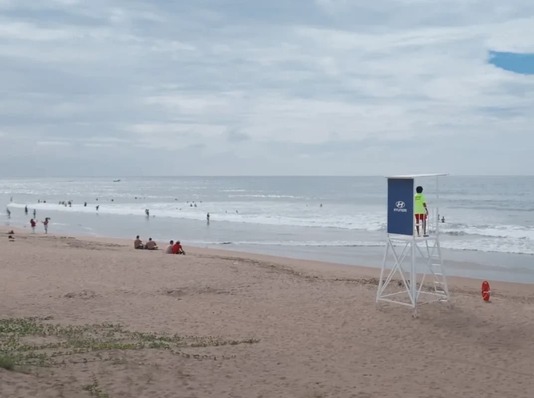 A lifeguard tower carrying a Hyundai panel at the waterline, a lifeguard on its deck
