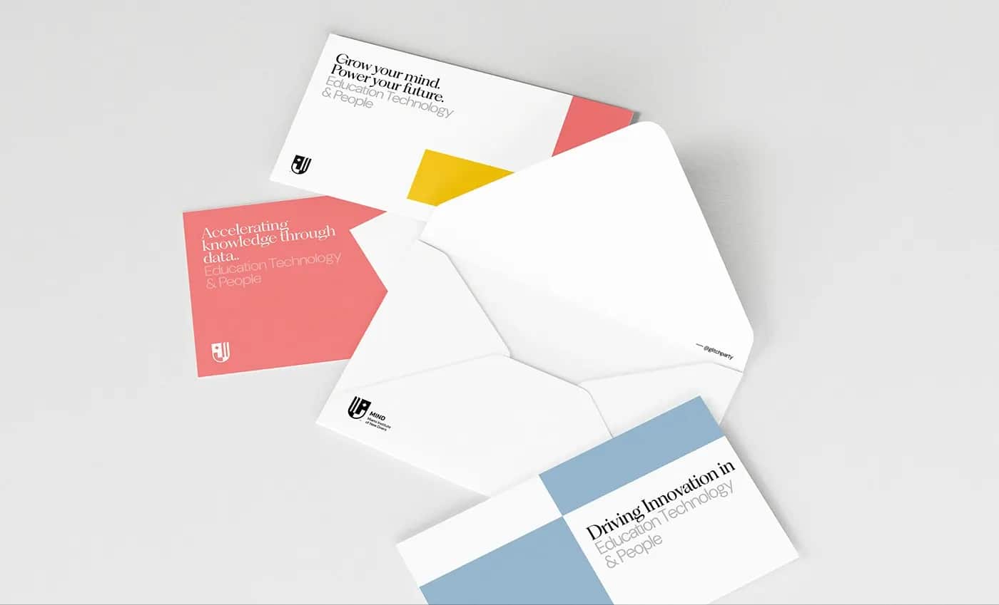 An opened white envelope with three colour-blocked correspondence cards on grey.