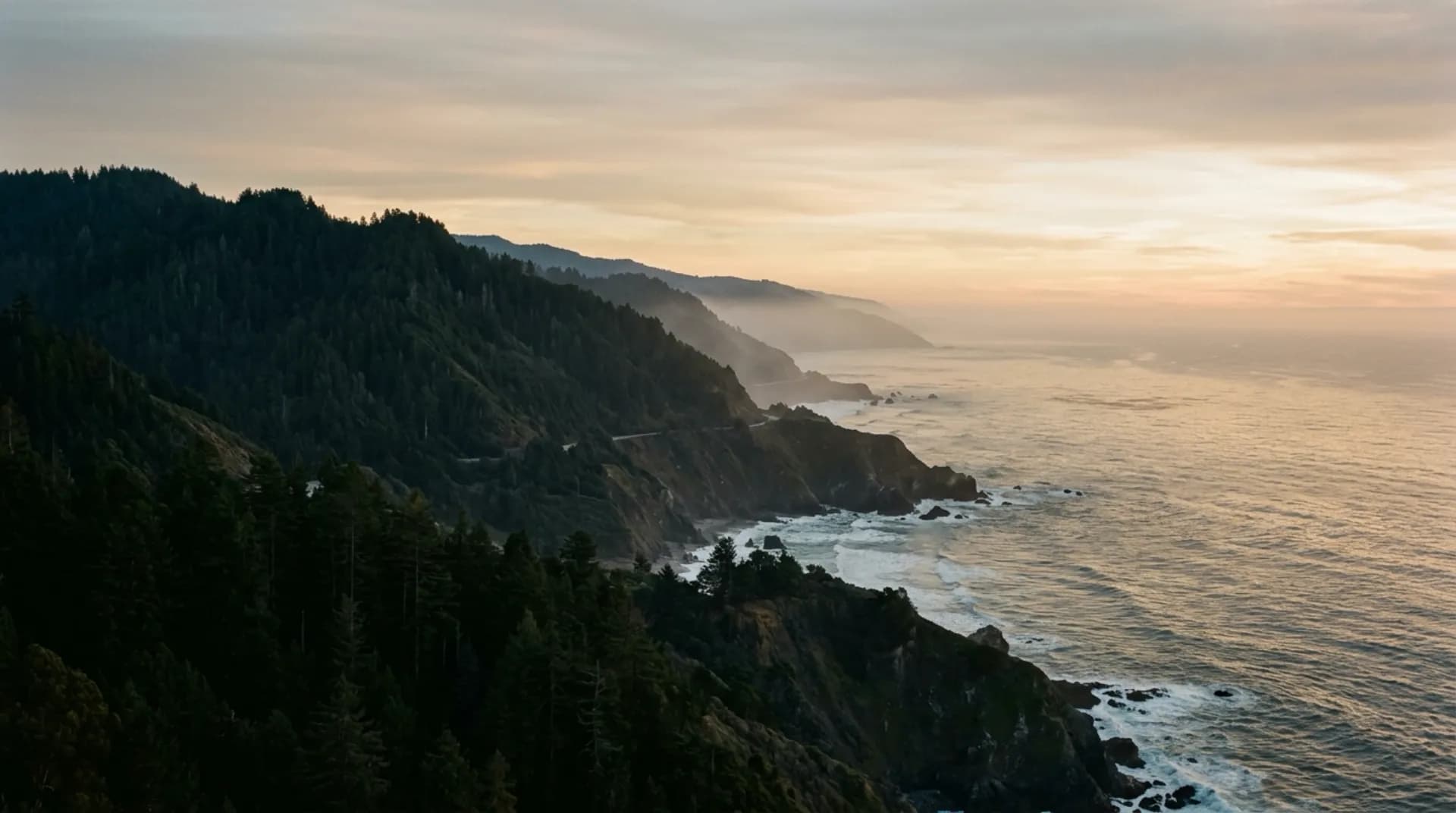 Redwood ridges dropping to the Santa Cruz coastline in evening haze