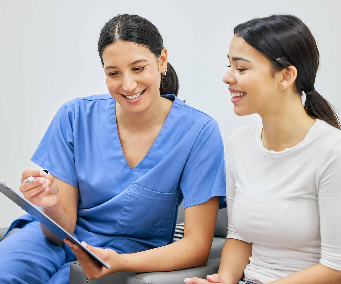 A staff member going through paperwork with a smiling patient.