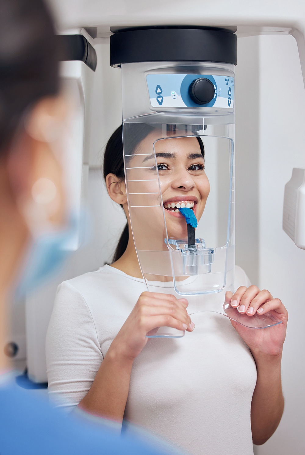 A patient standing at a panoramic X-ray machine.