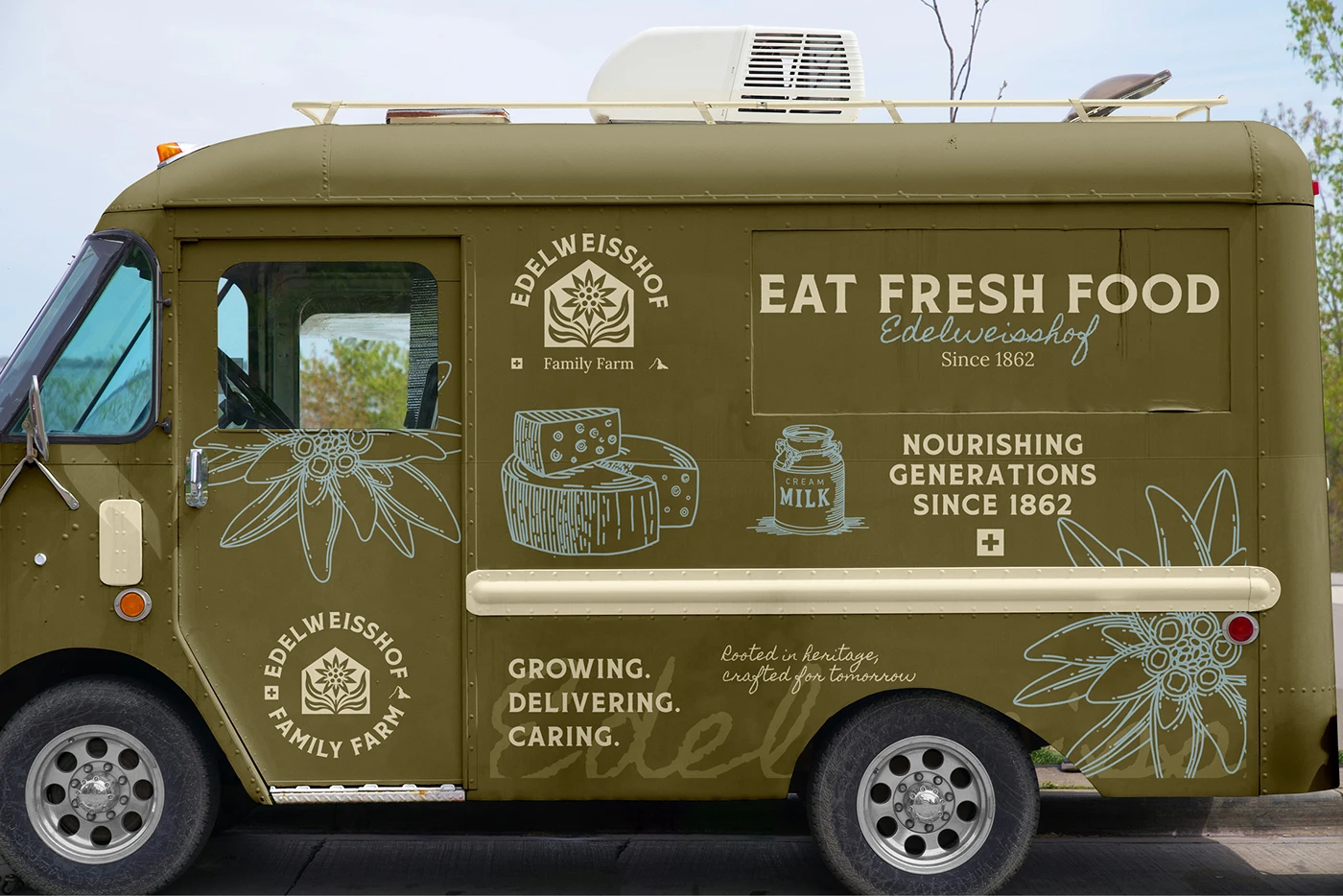 A moss-green Edelweisshof delivery van lettered “Eat Fresh Food” and “Growing. Delivering. Caring.”, with line drawings of cheese and a milk jar and an edelweiss sprawling across the panels