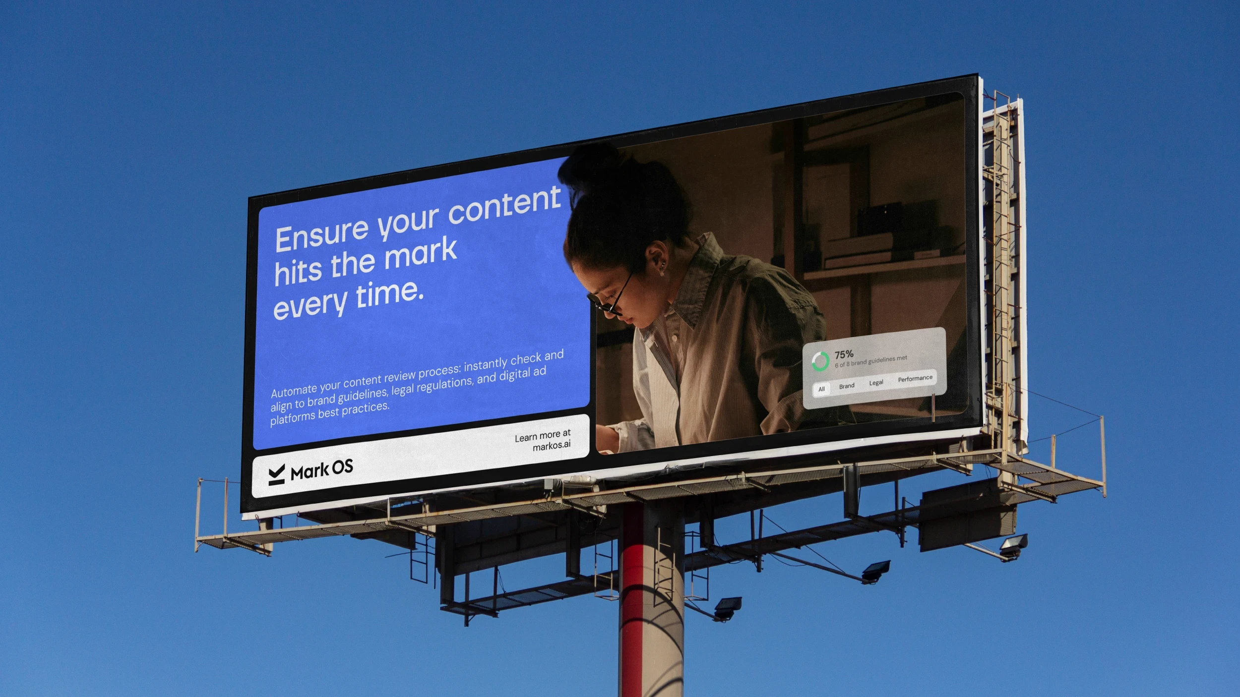 A Mark OS billboard against blue sky: the campaign headline beside a designer at work, with a 75% brand-guidelines score overlaid