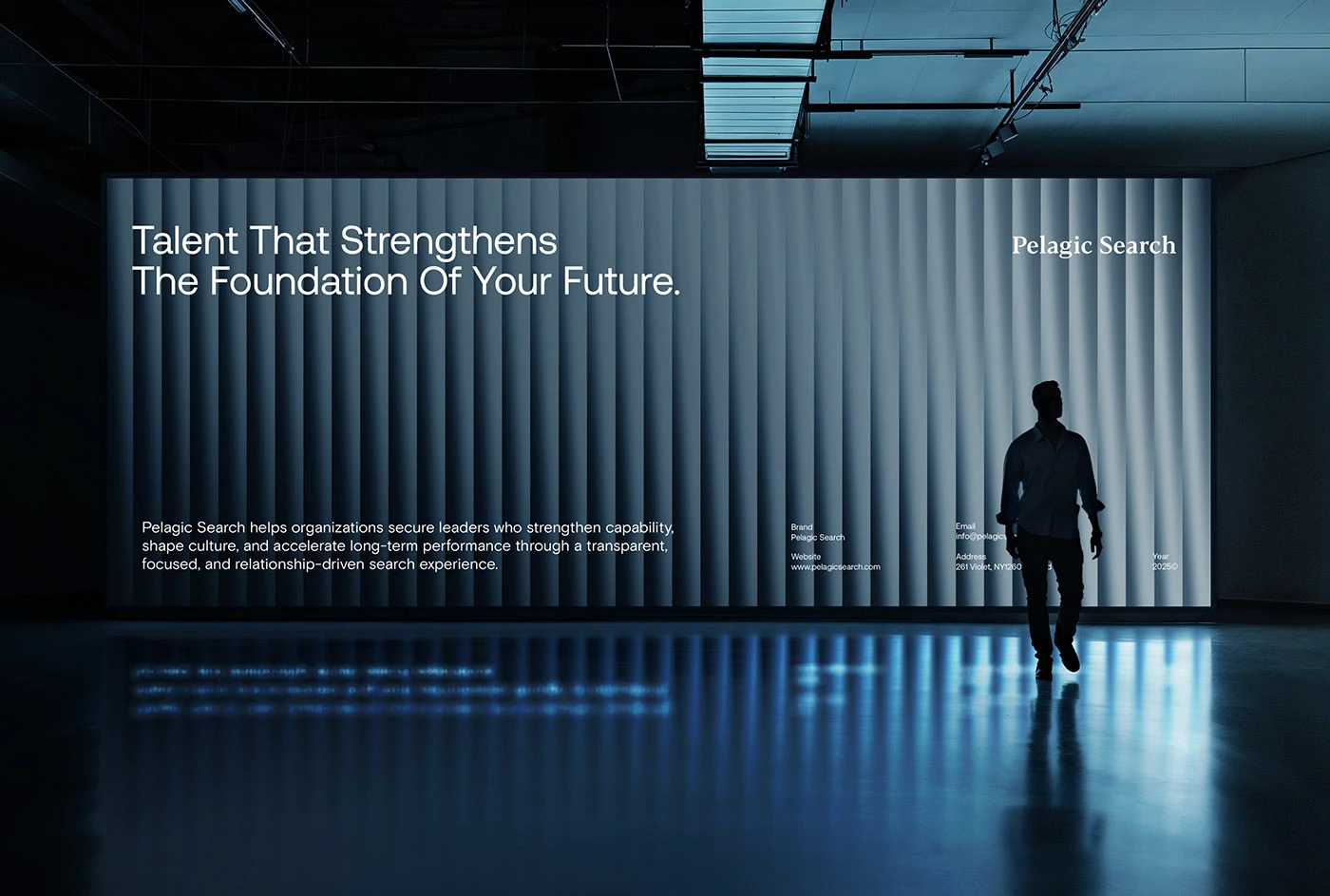 A figure walking past a room-scale fluted LED wall carrying the Pelagic Search campaign line and brand details, its light reflected across the polished floor
