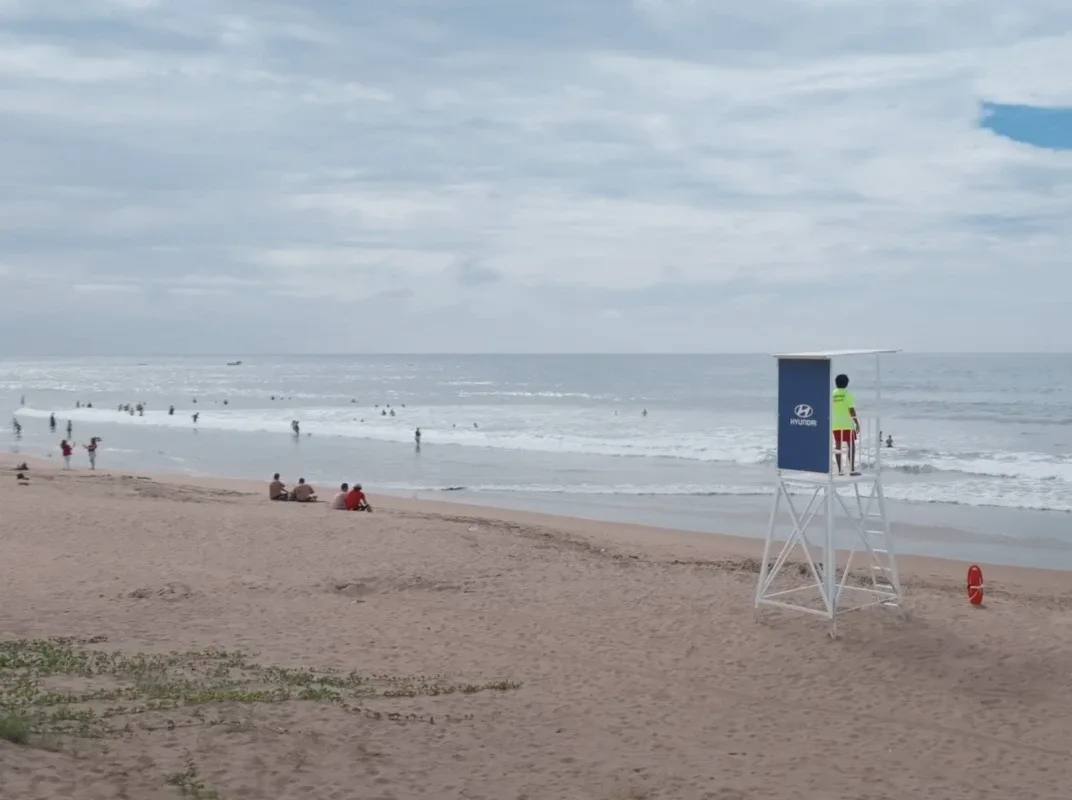 A lifeguard tower carrying a Hyundai panel at the waterline, a lifeguard on its deck