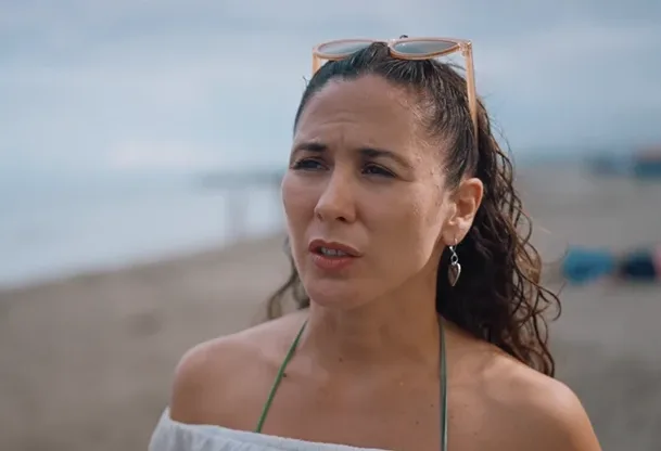 María Roca, a visitor to the beach, speaking to camera at the shoreline at dusk