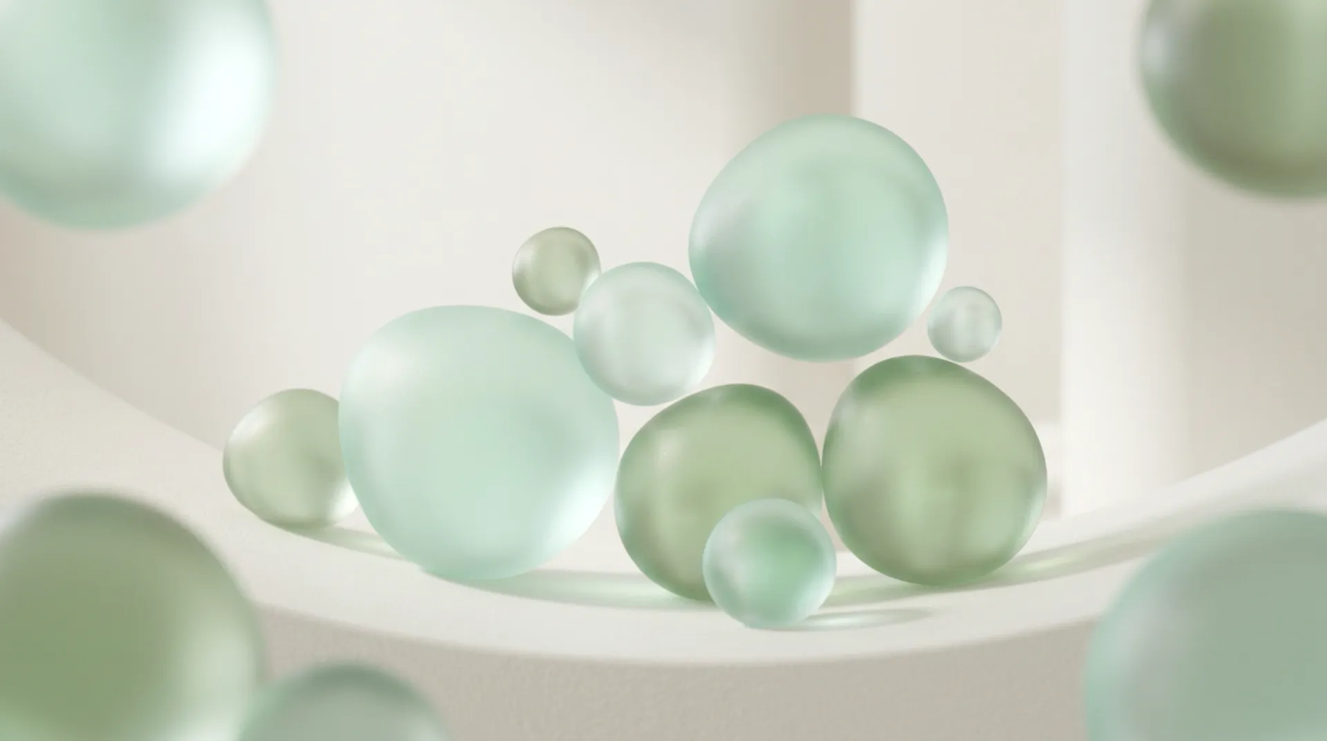 A cluster of frosted green glass spheres resting on a pale ledge