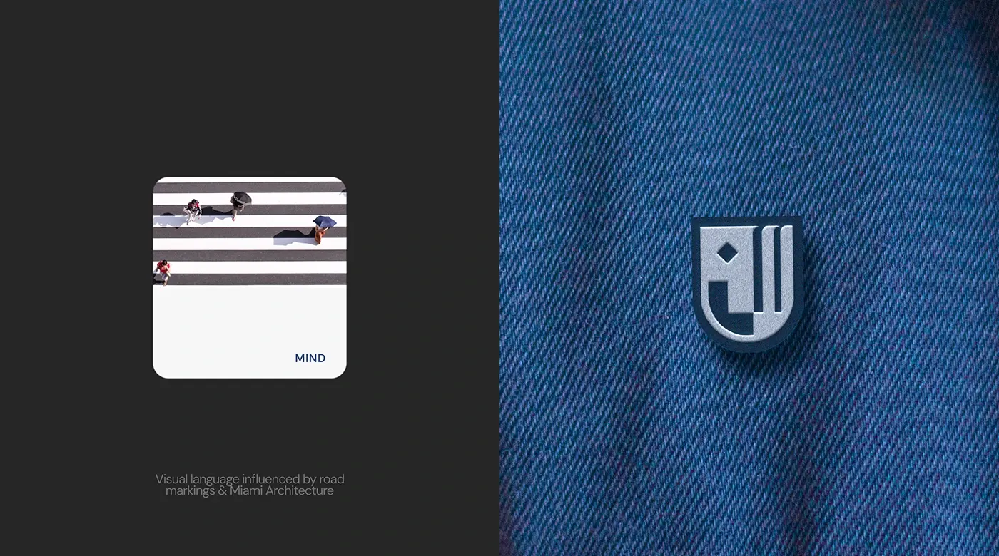 A pewter enamel monogram pin on the placket of an indigo denim shirt.