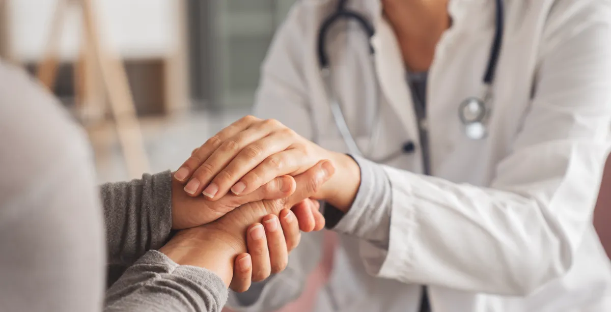 A clinician and patient in a bright consultation room